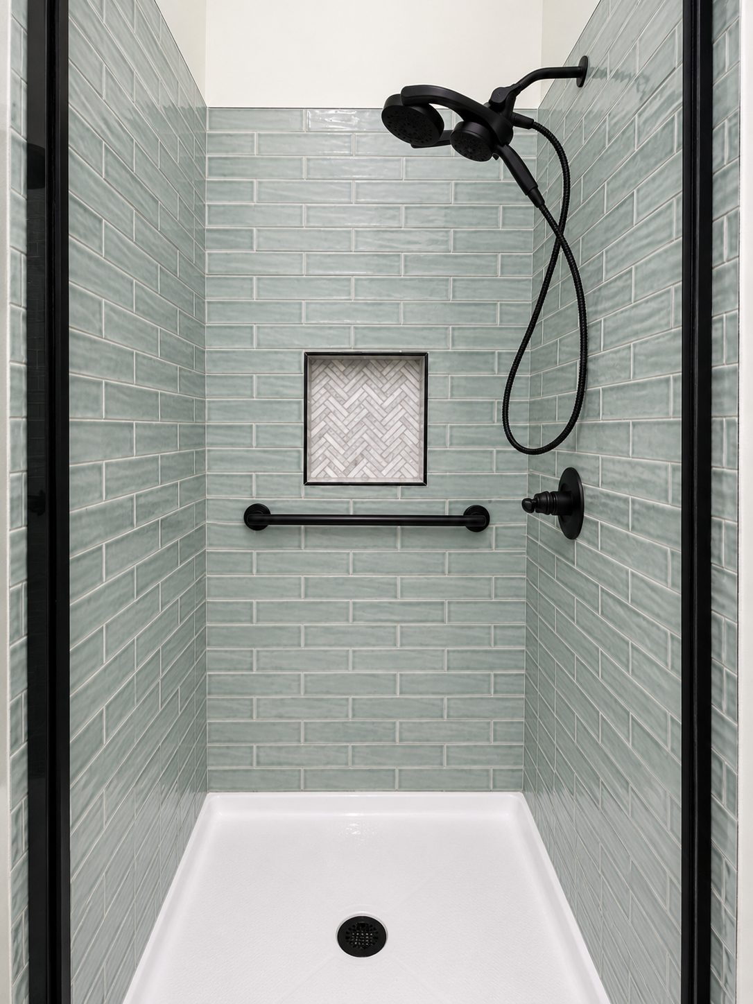 Sage green tile shower with herringbone niche